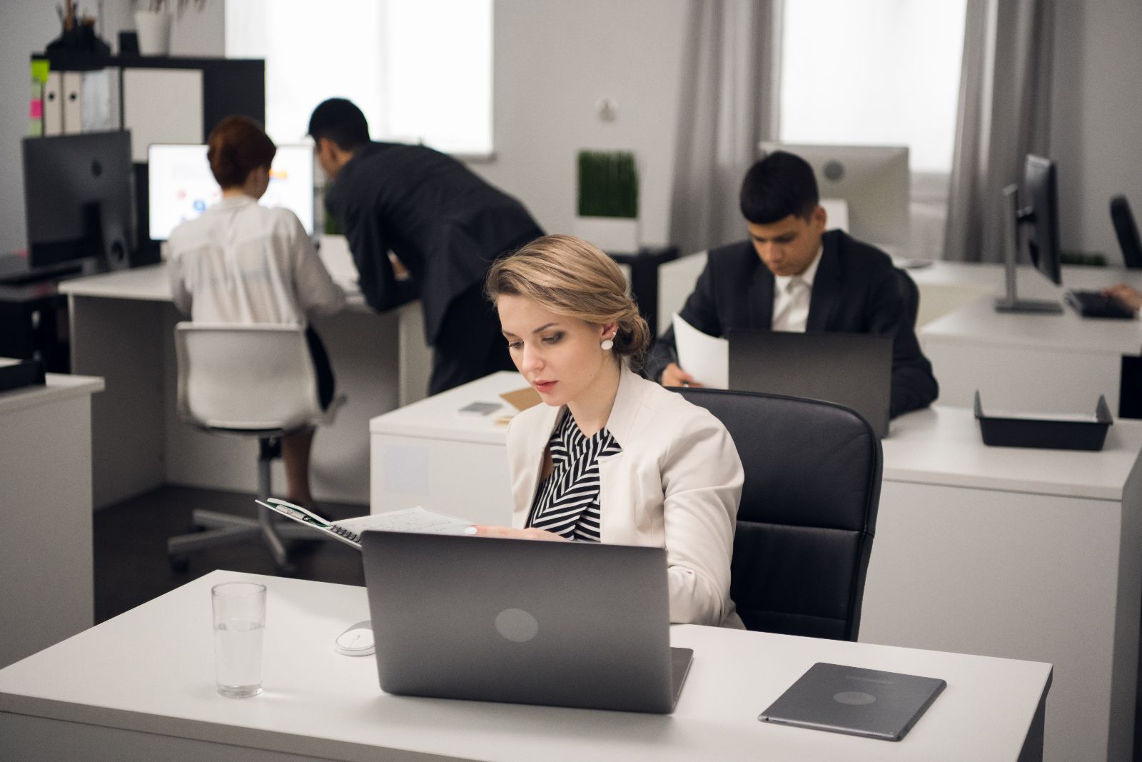 The Manager is busy with office work at a Desk in the open-space office of a large company.